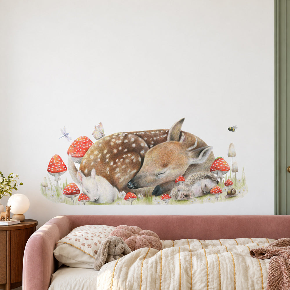 Sleeping Doe by Olivia Bezett, wall decal room mock-up in a bedroom above a pale pink bed.