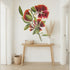 Floral wall mural in a room with a wooden table and decorative items.