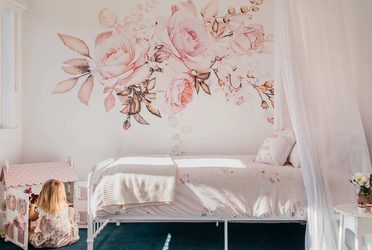 Pink floral wall graphics above a bed in a child’s bedroom