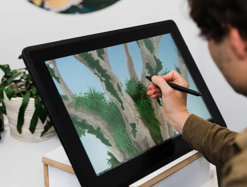 A YDS Studio artist drawing a landscape on a pen display
