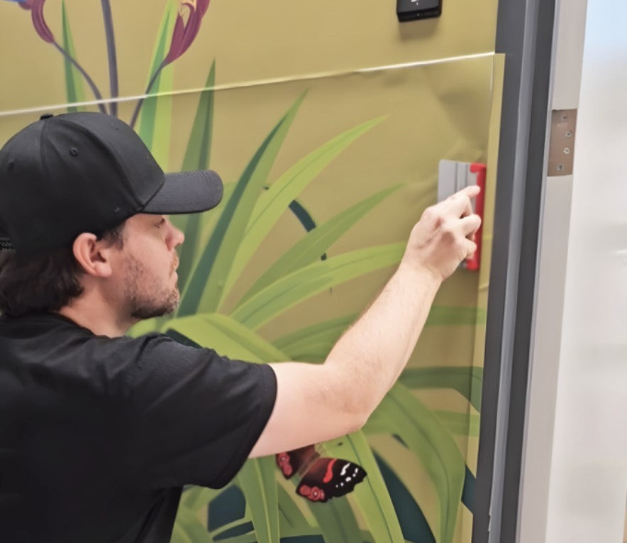A YDS Studio installer applying a large-format wall mural