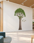 Kauri Tree & Waxeyes wall decal visualisation in a modern library family zone, gentle angled view.