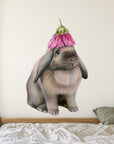 Rabbit with Flower Hat by Olivia Bezett, wall decal room mock-up in a bedroom above patterned bedding.