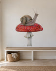 Snail on Mushroom by Olivia Bezett, wall decal room mock-up in a room above a white desk.
