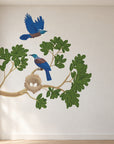 Tūī nest and leafy branch wall decal in a bright designer room, view 1.